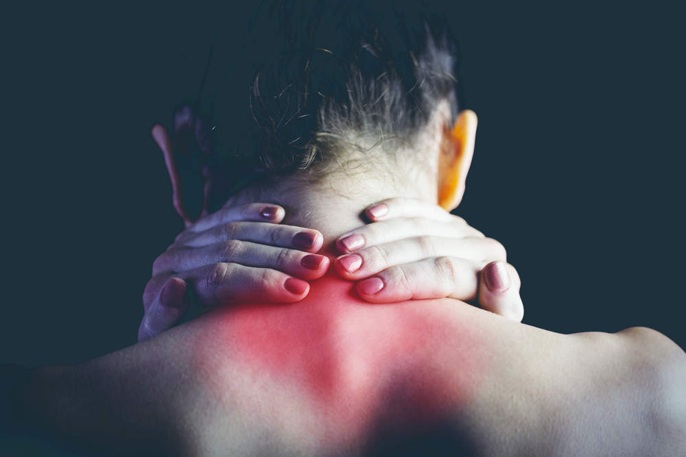 Woman with muscle injury holding neck