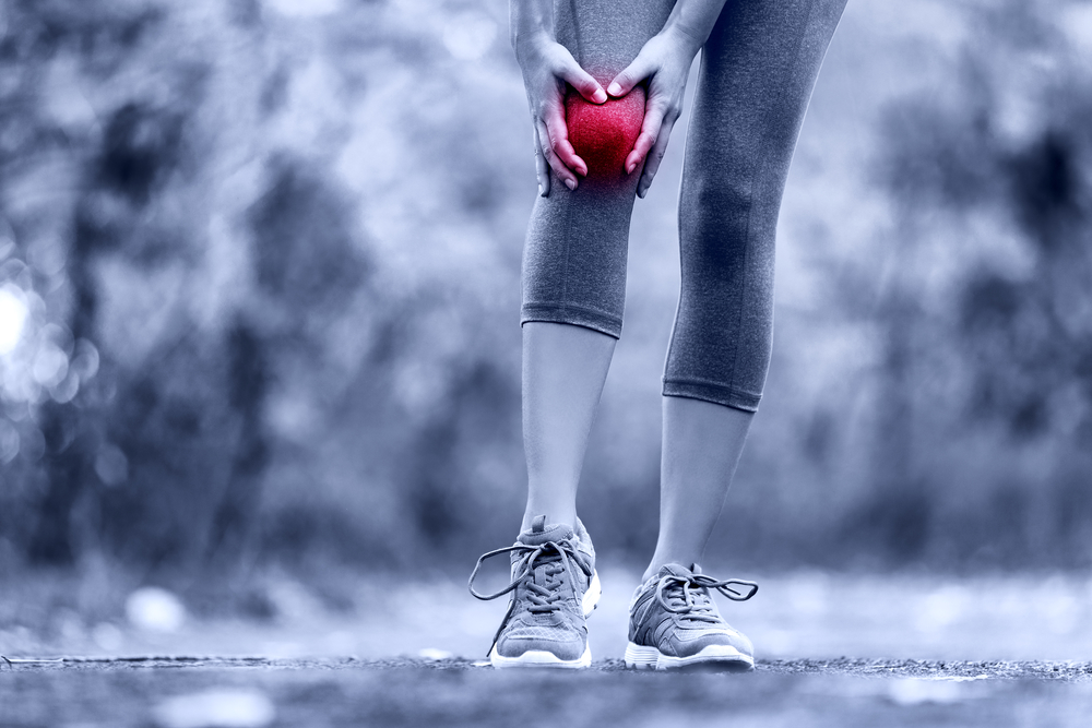 woman stopped running feeling pain in her knee