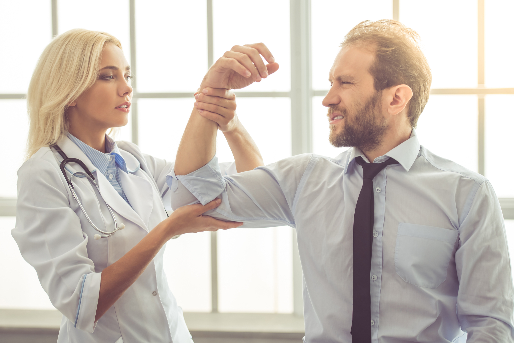 Doctor with patient examining hand