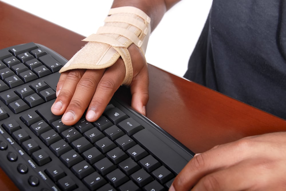 man with wrist brace on while typing