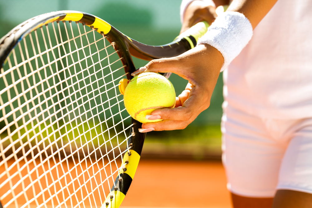 Male tennis player holding racket and ball