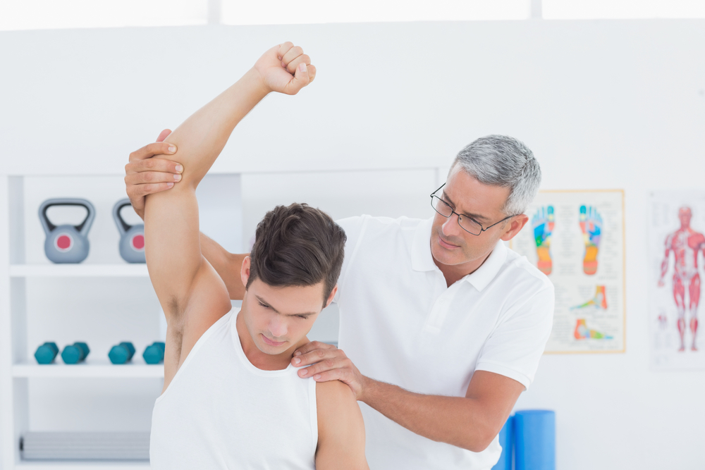 man stretching arm with doctor
